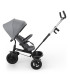 Triciclo Kinderkraft Aston 2 Plus gris con el respaldo semirreclinado mirando a los padres y capota para el sol