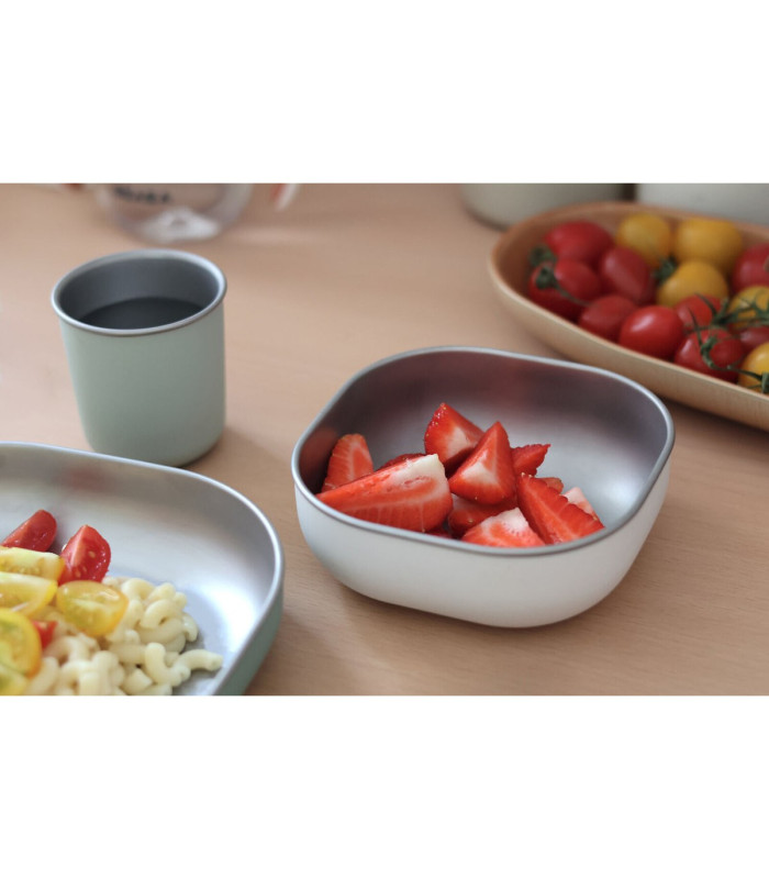 Vajilla inox Béaba verde salvia en la mesa con pasta en el plato y fresas en el bol