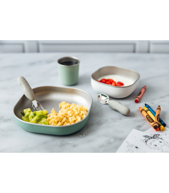 Plato inox Béaba verde salvia con comida junto a cubiertos de aprendizaje Béaba que se venden aparte