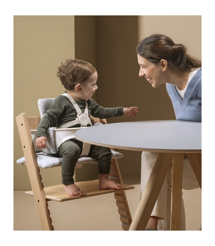 Bebé comiendo en la Tripp Trapp con el arnés Stokke beige puesto