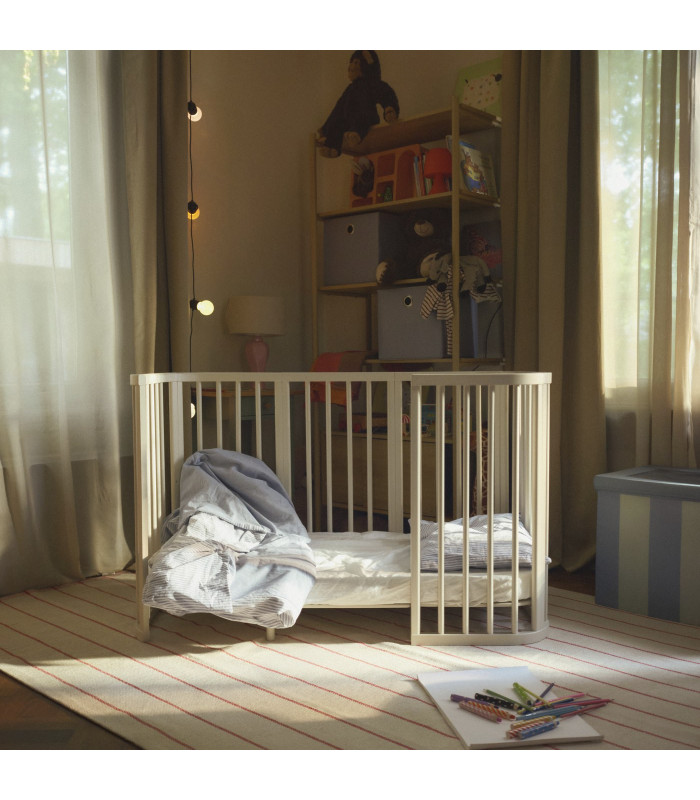 Cama infantil Stokke Nighti Vanilla White en un dormitorio