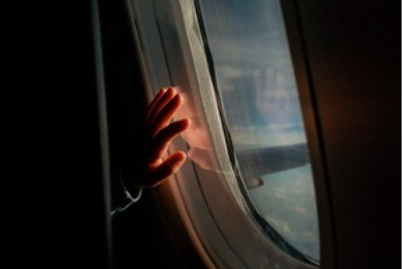Niño mirando por ventana de avión